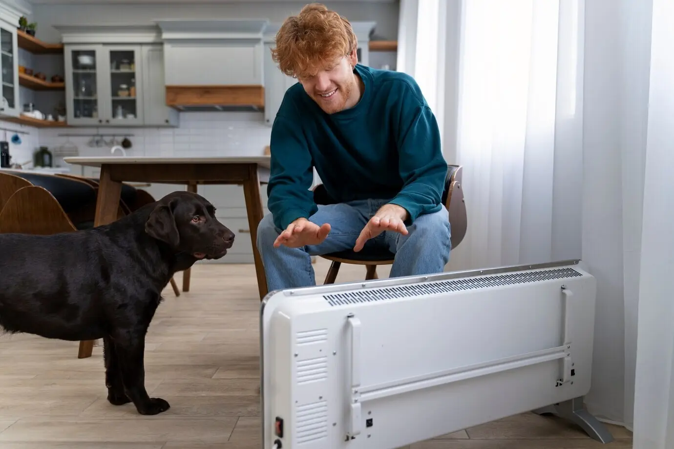 A full shot of a smiling man and a dog at home.