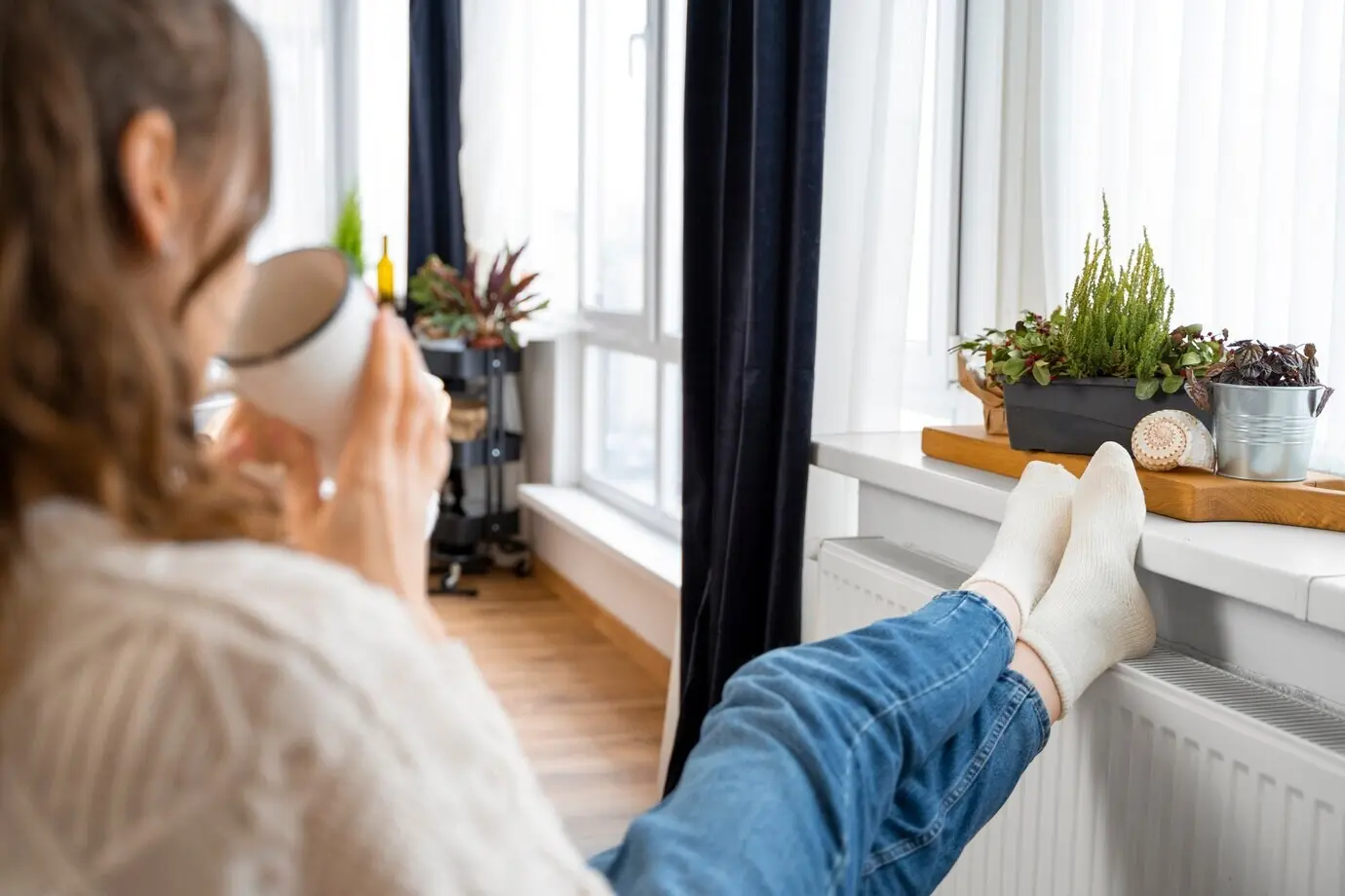 Close-up of a woman sitting near a heater.