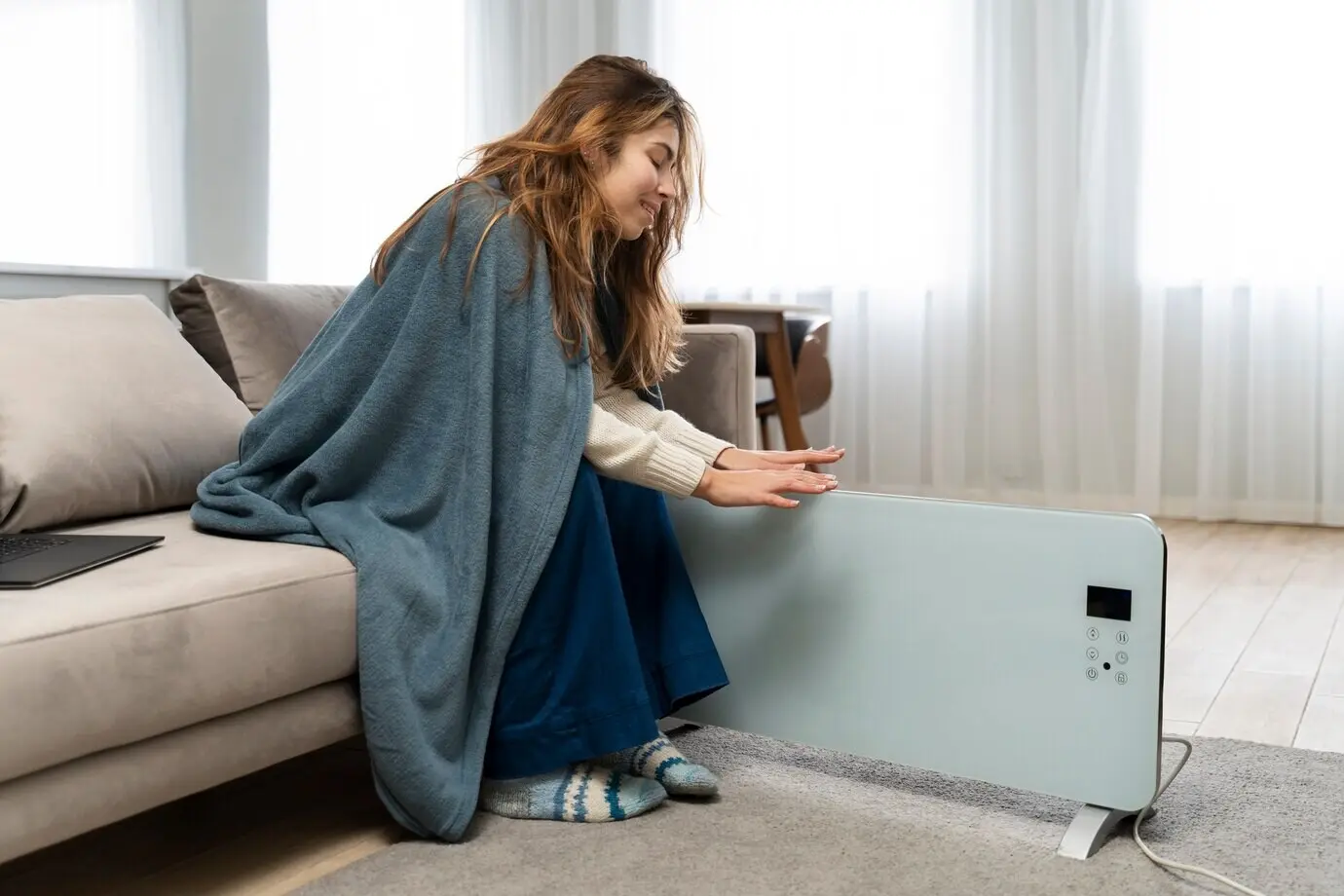Full-length shot of a smiling woman near a heater.